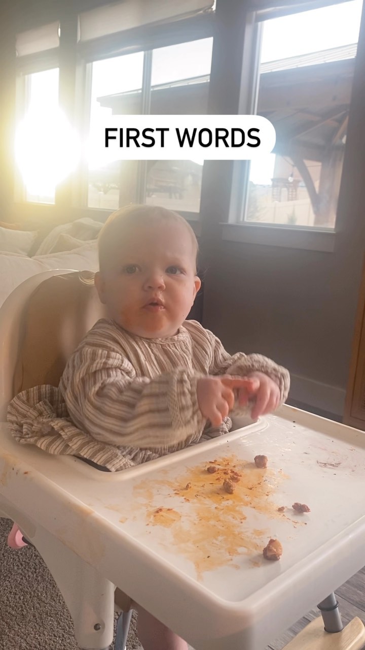 Baby in a high chair exploring food during a feeding session.